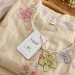 Close-up of colourful floral embroidery on an ivory crushed tissue suit
